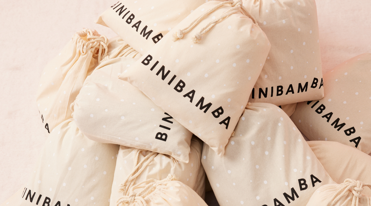 PERSONALISED SHEEPSKIN PRAM LINER IN MILK COLOUR. CHILD WEARING BRUNO BROWN GILET