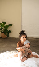 Load image into Gallery viewer, sheepskin binibear being held by a baby and his sister