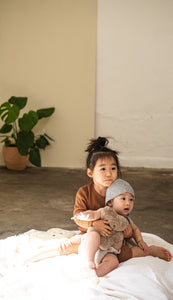 baby and little girl holding sheepskin teddy bear